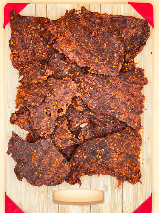 Dried beef jerky on a wooden cutting board
